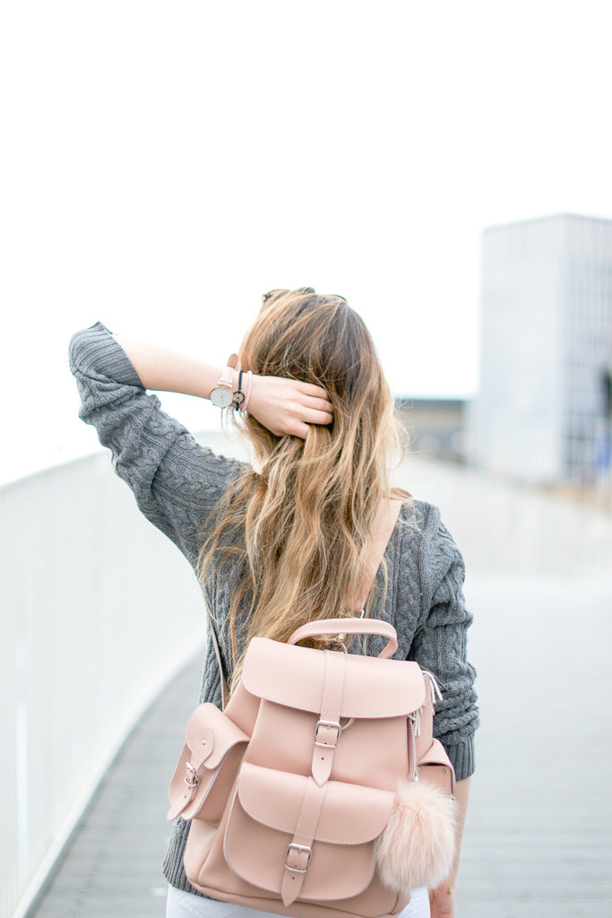 Un petit sac à dos noir accompagné de son pompon