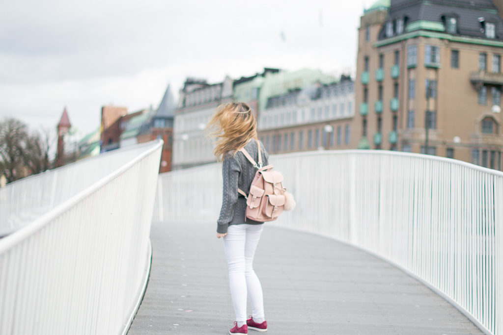 Un petit sac à dos noir accompagné de son pompon